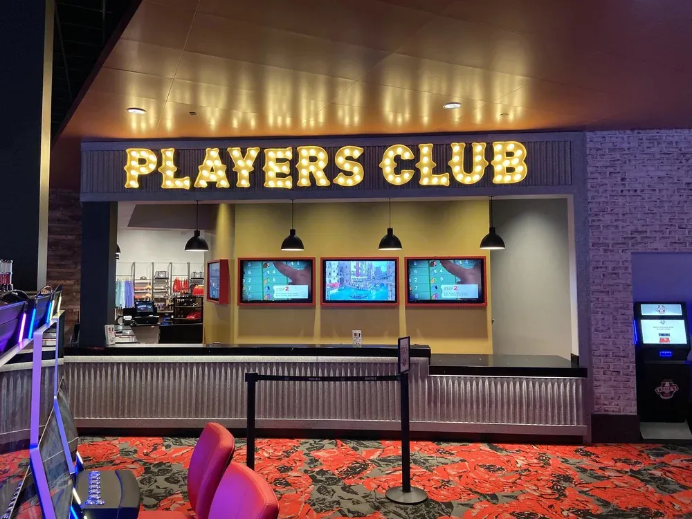 Finished entertainment venue lounge with illuminated signage and screens