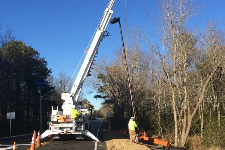 Crane truck setting equipment at a roadside job site