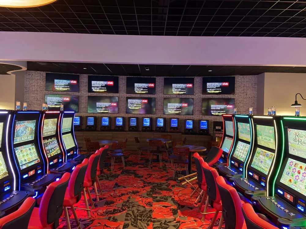 Rows of gaming machines and screens powered on a venue floor