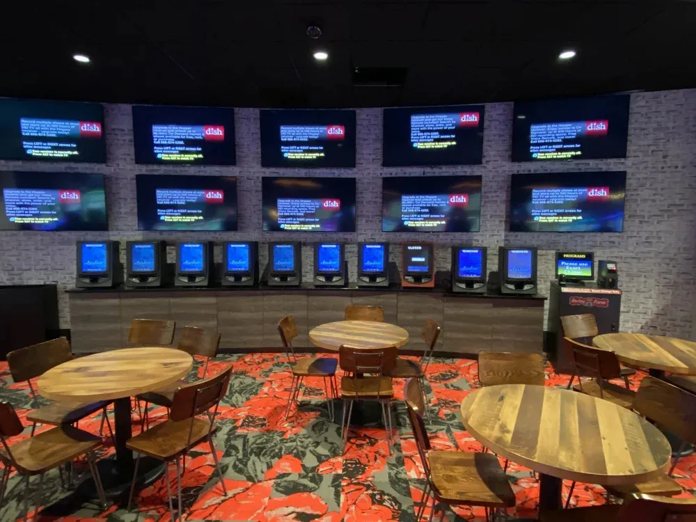 Sports bar seating area with wall of screens and ceiling lighting
