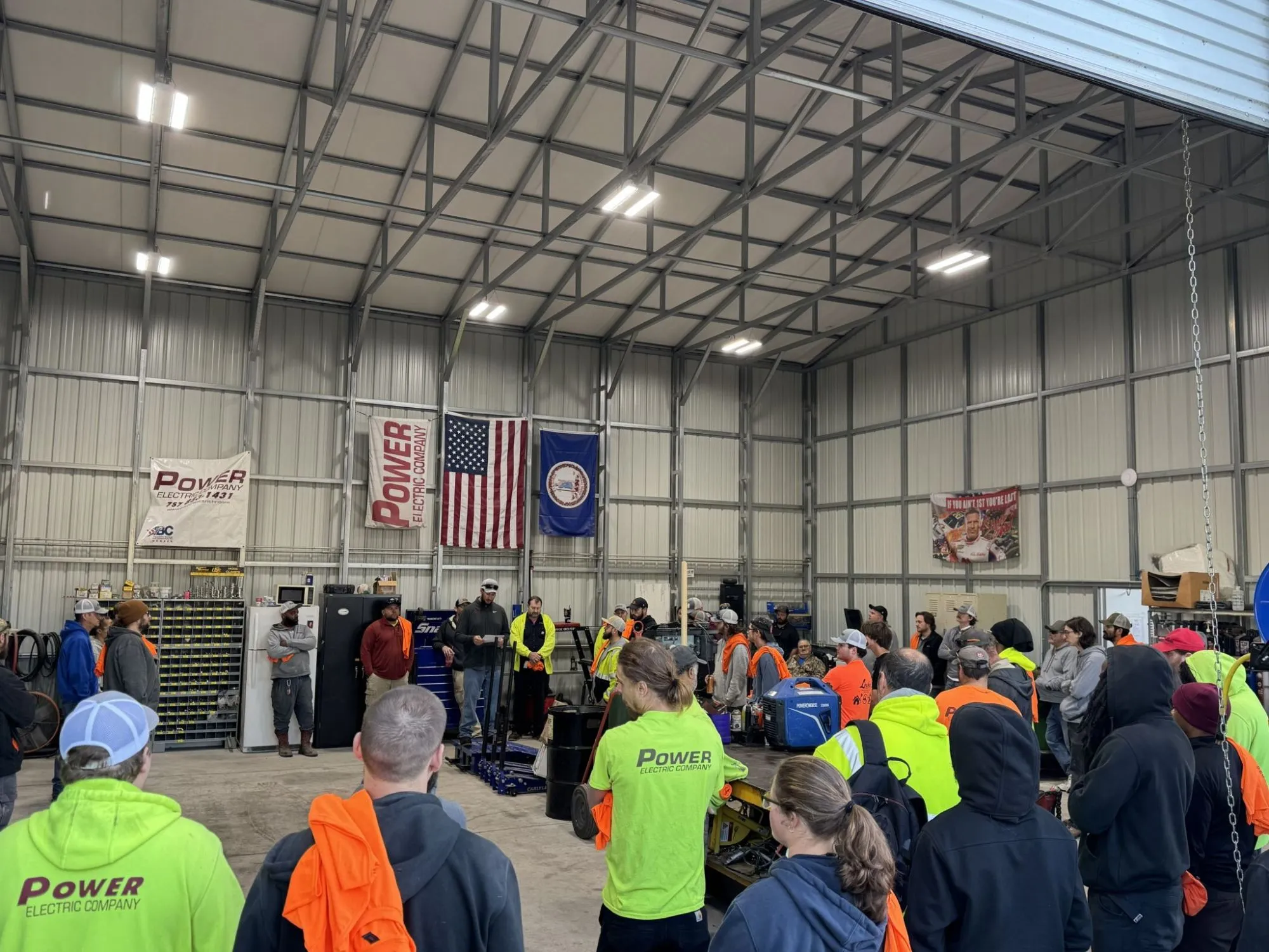 Power Electric crew gathered for a team meeting in the company shop